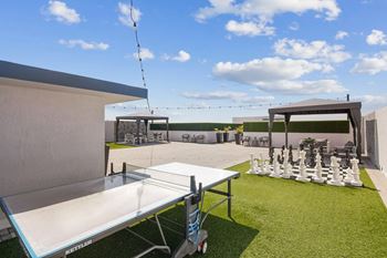 A white table tennis table is set up on a grassy area.